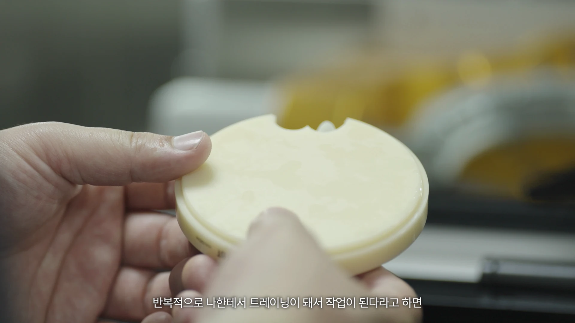 技工室负责人的双手拿着小型圆盘仔细查看